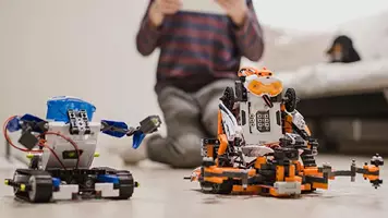 03 IOTA Boy Using Tablet And Robots